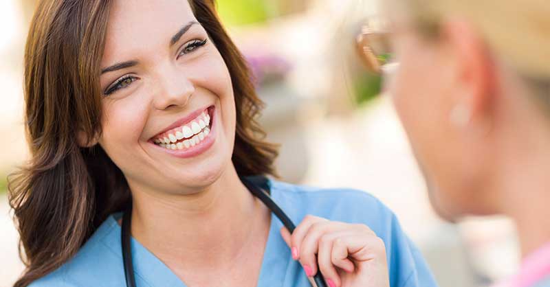 Smiling nurse talking with a woman outside