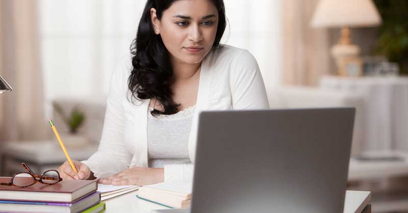 woman sitting at desk looking at laptop