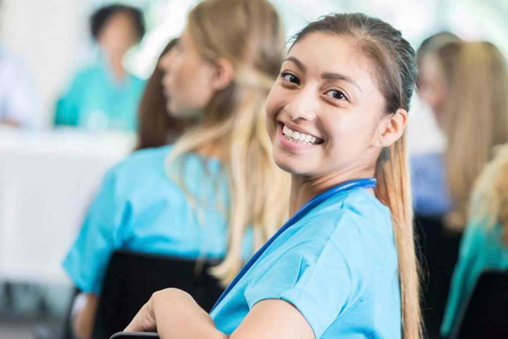 smiling nurse looking behind her in class